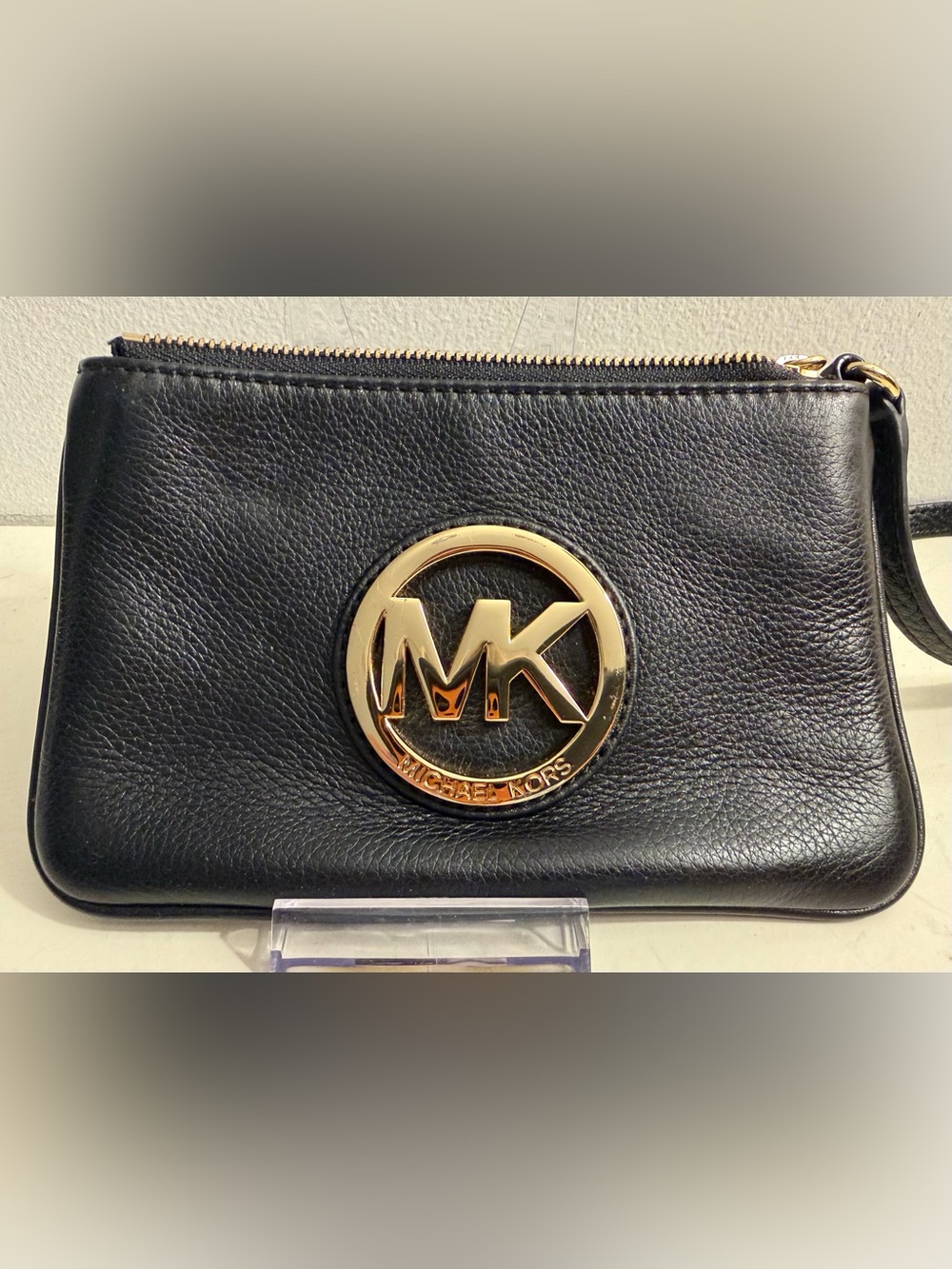 Michael Michael Kors black pebbled leather wristlet with gold toned hardware.